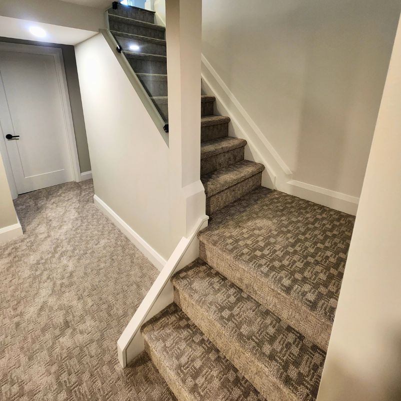 Newly carpeted basement stairs with glass insert.