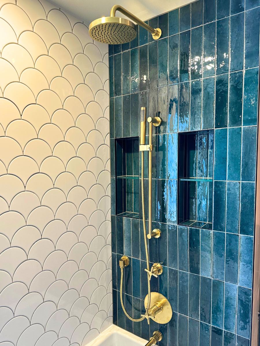 Close up of renovated shower corner where white tiles meet teal.