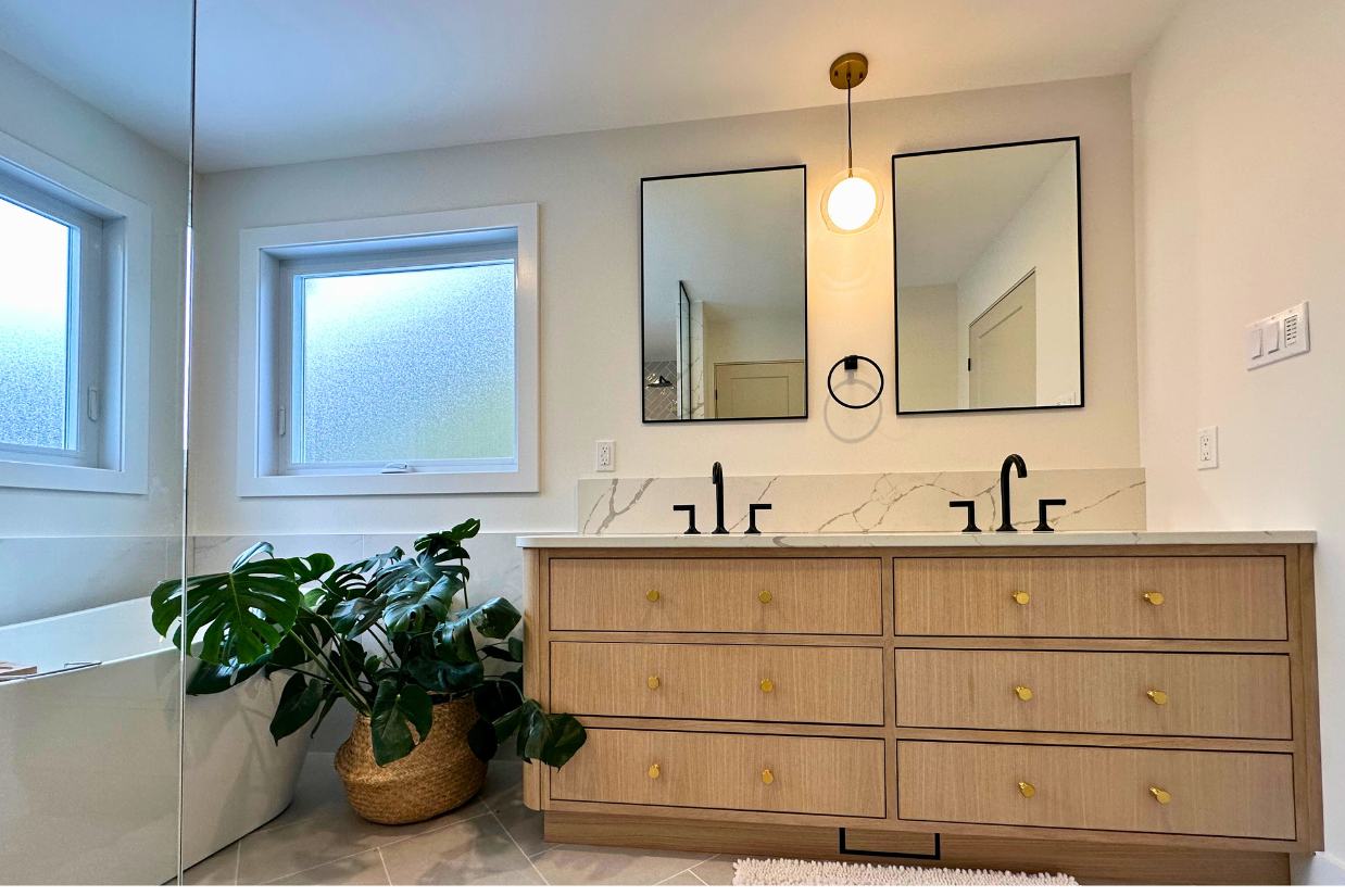 Double vanity in renovated Ottawa bathroom with a large plant beside.