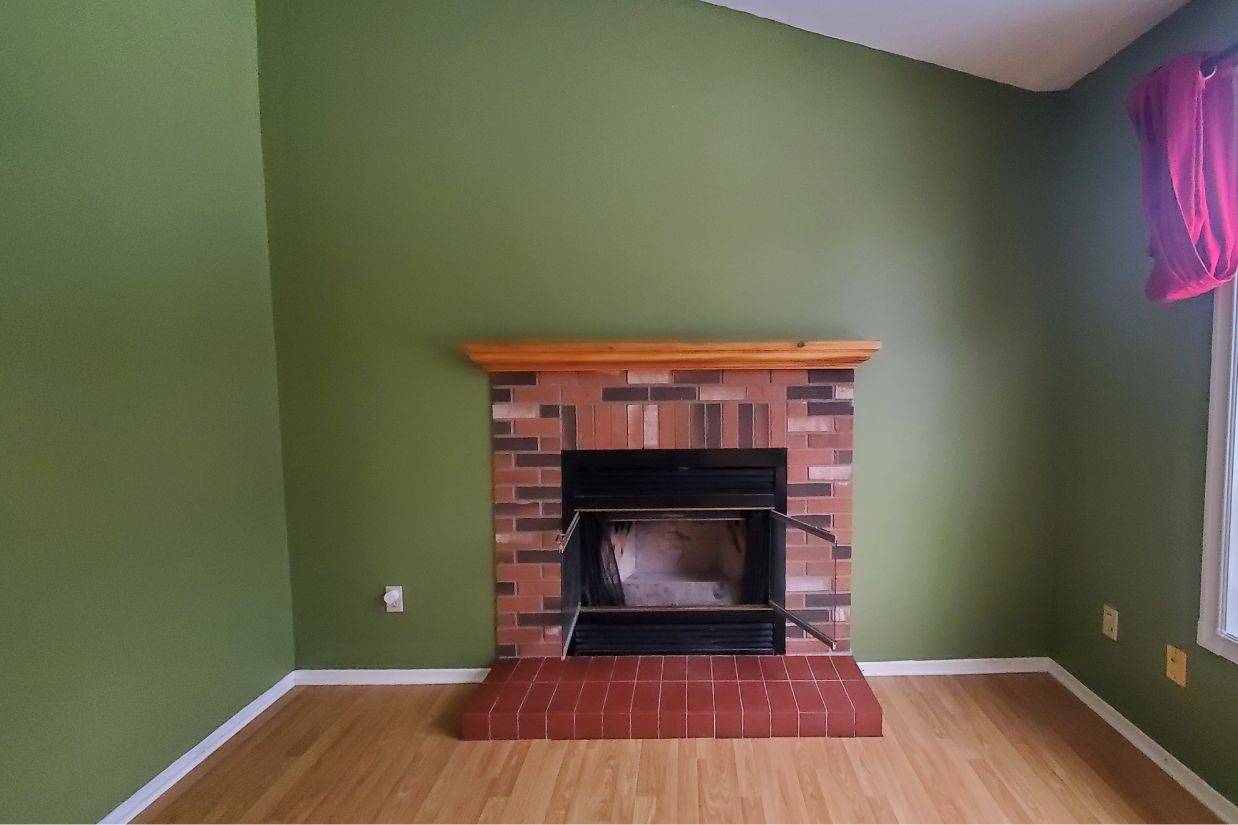 Before: Red brick fireplace against medium green wall.