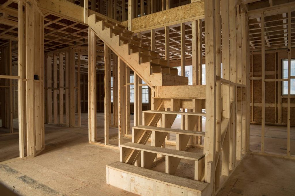 Inside of a newly framed home looking at the staircase.