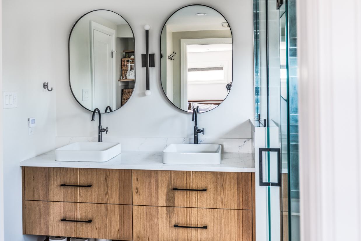 Vanity shot straight on with dual sinks and oval mirrors.