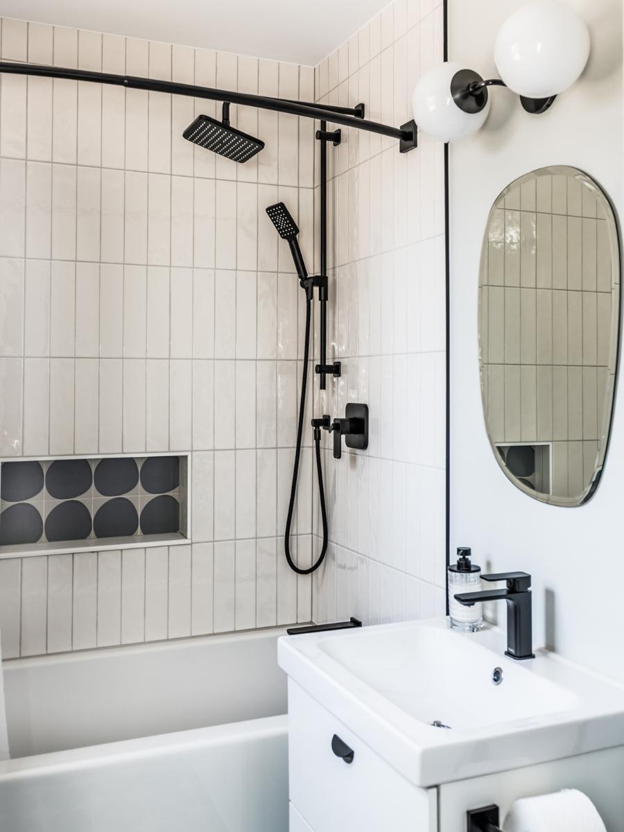 Second bathroom with white tiles and black accents.