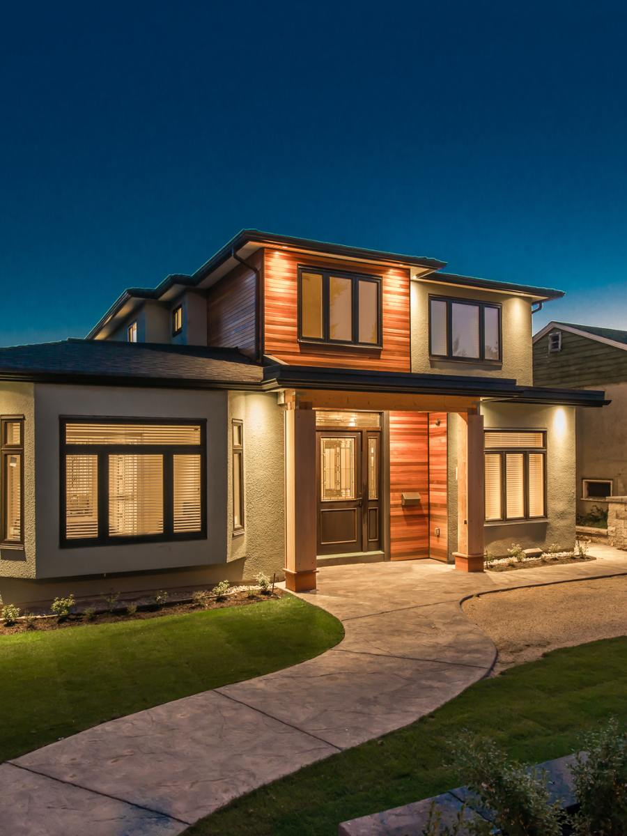 Custom home at dusk with well-lit front face.